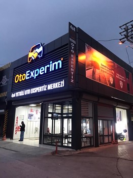 Oto Experim İzmir şubesinin akşam aydınlatılmış dış cephesi